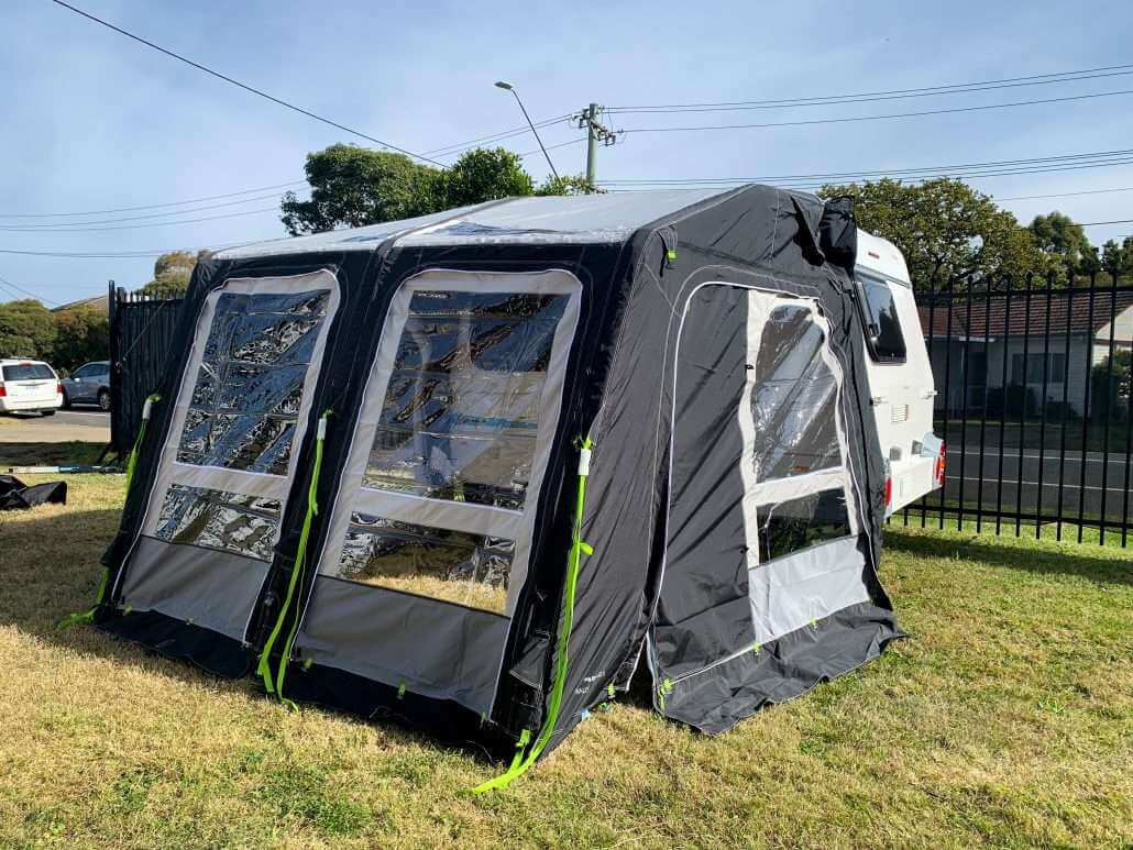 Dometic inflatable annex displayed on euro caravan on grass. Showing its side and back view with the doors on.